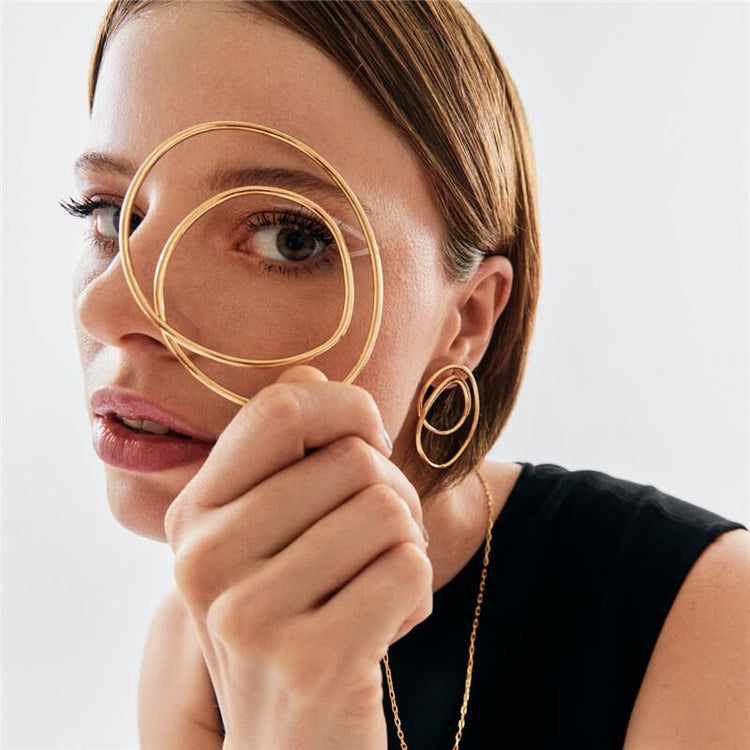 Mulher usando semijoias de alta qualidade em 18k e 24k, incluindo colar e anéis antialérgicos, destacando sofisticação e leveza.