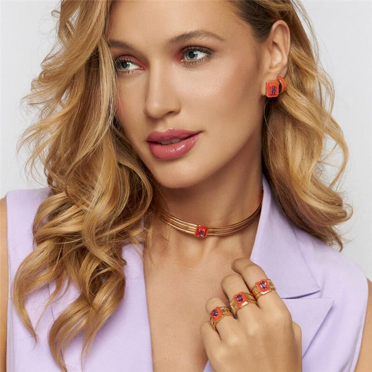 Modelo usando semijoias antialérgicas da Coleção AMATTA, em tons de laranja, com cristal ametista, em ouro 18k e 24k.