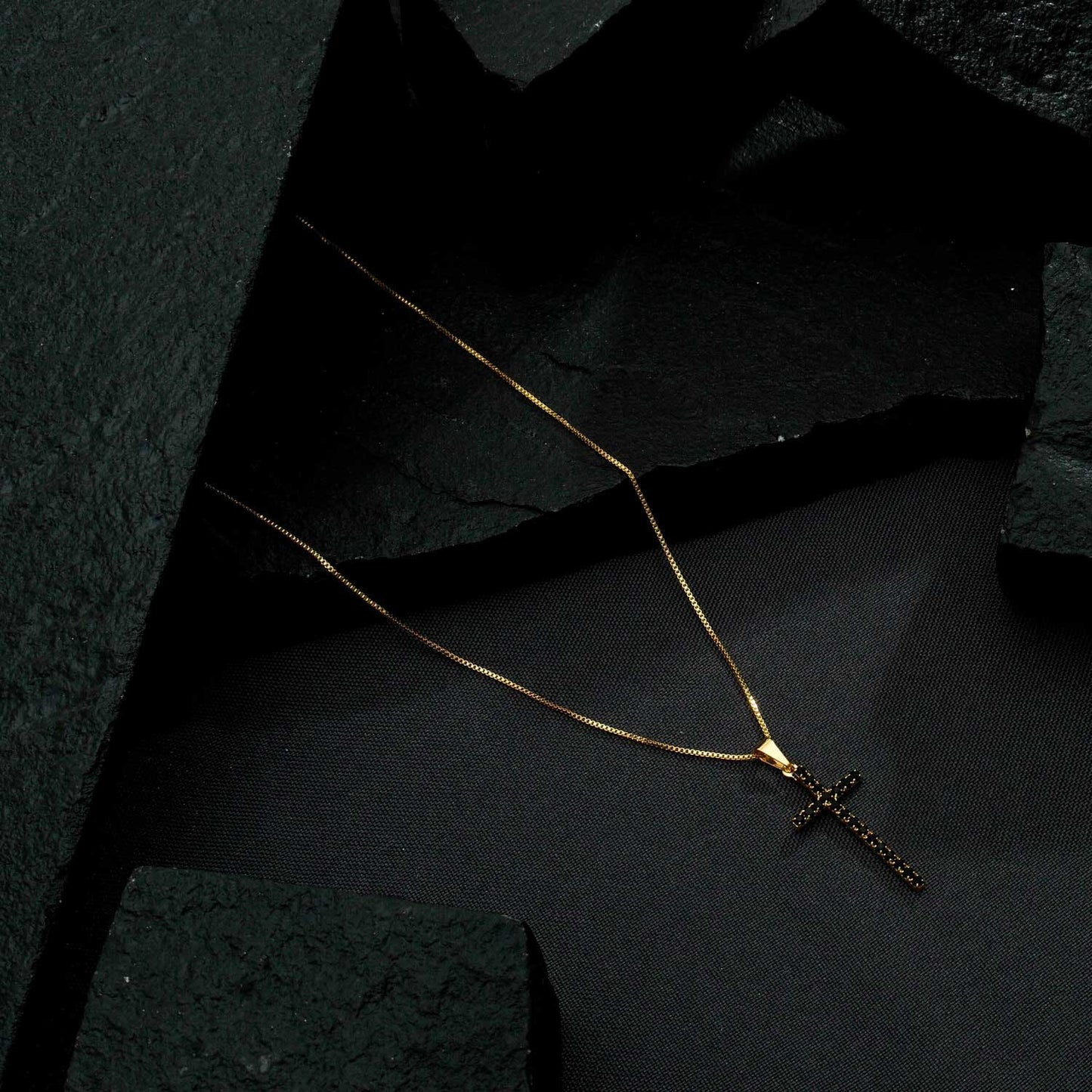Colar dourado de cruz cravejado com pedra natural negra, semijoias de alta qualidade em 18k e 24k, tecnologia antialérgica.