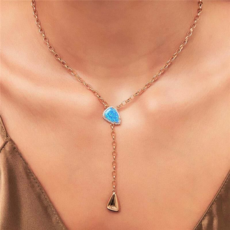 Mulher usando brincos e anel da coleção ZURI, semijoias de alta qualidade em ouro 18k, com pedra azul central, design moderno e elegante.