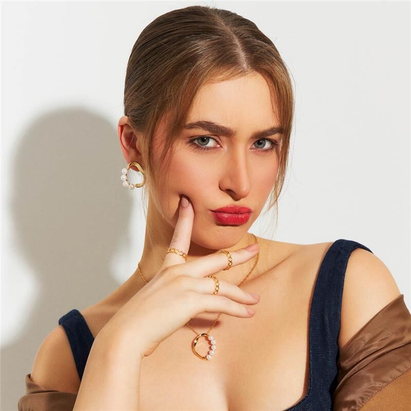 Mulher usando colar Perla Flow semi joias antialérgica em 18k e 24k de alta qualidade com pérola e banho dourado.