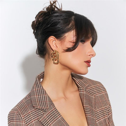 Mulher usando argola Quattro dourada com zircônia e cristal, semijoia de alta qualidade com material antialérgico em 18k e 24k.