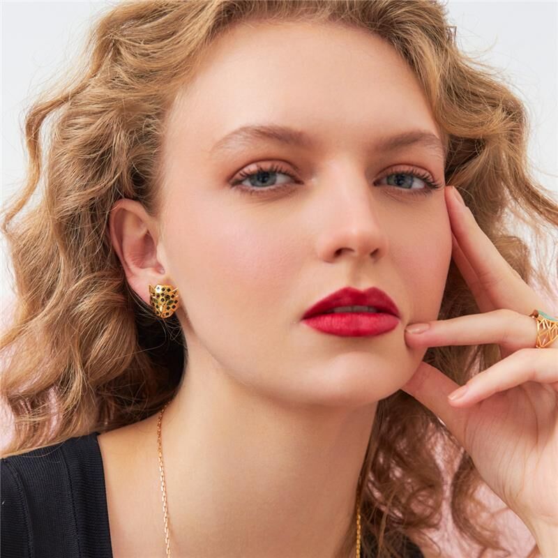 Mulher usando Brinco Leo Pintado com zircônia, semijoia antialérgica banhada a ouro 18k e 24k, elegante e de alta qualidade.