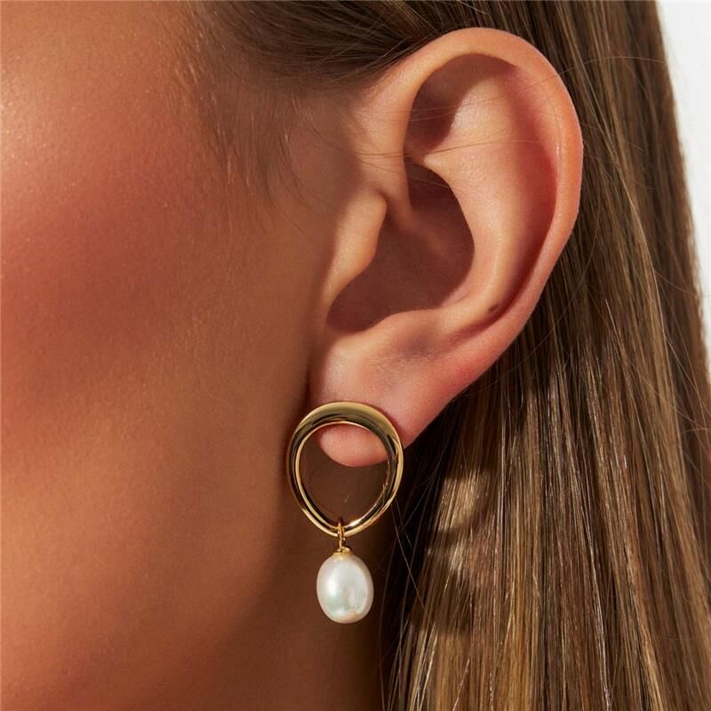 Brinco Perla Flow em ouro dourado com pérola, semijoia antialérgica 18k de alta qualidade, elegante em orelha feminina.