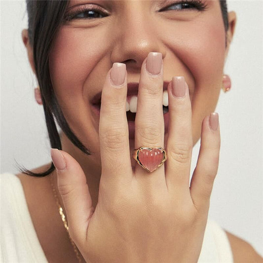 Mulher sorrindo usando anel Encanto Rosé, semijoia de alta qualidade em 18k, com pedra de cristal, antialérgica e banho dourado.