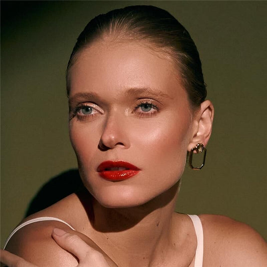 Mulher usando brinco Vertilux com banho dourado, semijoia antialérgica de cristal em 18k e 24k.