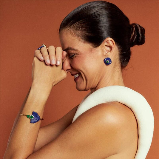 Mulher usando bracelete Pavão com cristais, em ouro dourado, semijoias de alta qualidade e tecnologia antialérgica; elegância discreta.