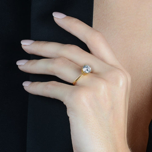 Anel de ouro 24k com zircônia G, semijoia antialérgica de alta qualidade no dedo de uma modelo elegante.