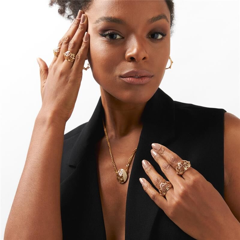 Mulher elegante usando colar dourado "Colar Forma Nobre" com zircônia, semijoia de alta qualidade e material antialérgico em 18k e 24k.