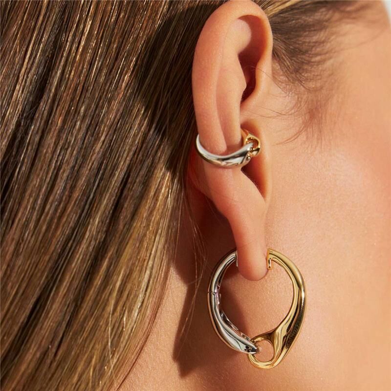 Aros Piercing Versa dourado e ródio em orelha, semijoias antialérgicas de alta qualidade. Peso 1,64g, altura 1.5cm, largura 1.2cm.