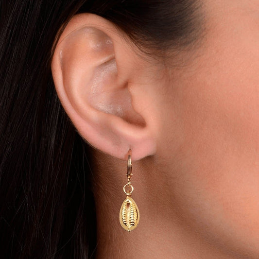 Mulher usando brinco dourado de argolinha com búzios, semijoias de alta qualidade em 24k, antialérgico e elegante.