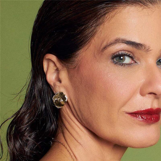 Mulher usando Brinco Vera de Flor com Zircônias, semijoia antialérgica banhada a ouro 18k, destacando elegância e sofisticação.