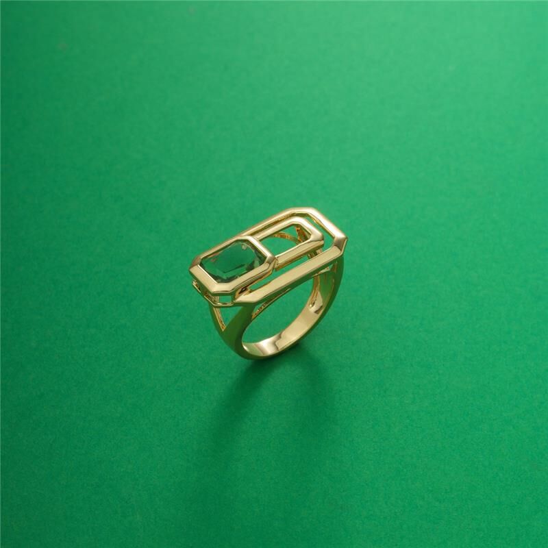 Anel Vertilux semijoia antialérgica com cristal e banho dourado, peso 6g, em fundo verde.