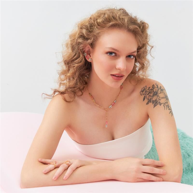 Mulher usando colar regulável Emilly, semijoia de alta qualidade com cristal e banho dourado, material antialérgico em 18k e 24k.