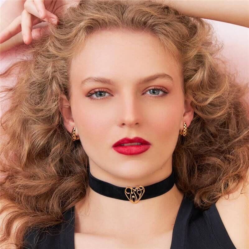 Mulher usando Brinco Felina, semijoia antialérgica esmaltada em ouro 18k, com acabamento dourado e design elegante.